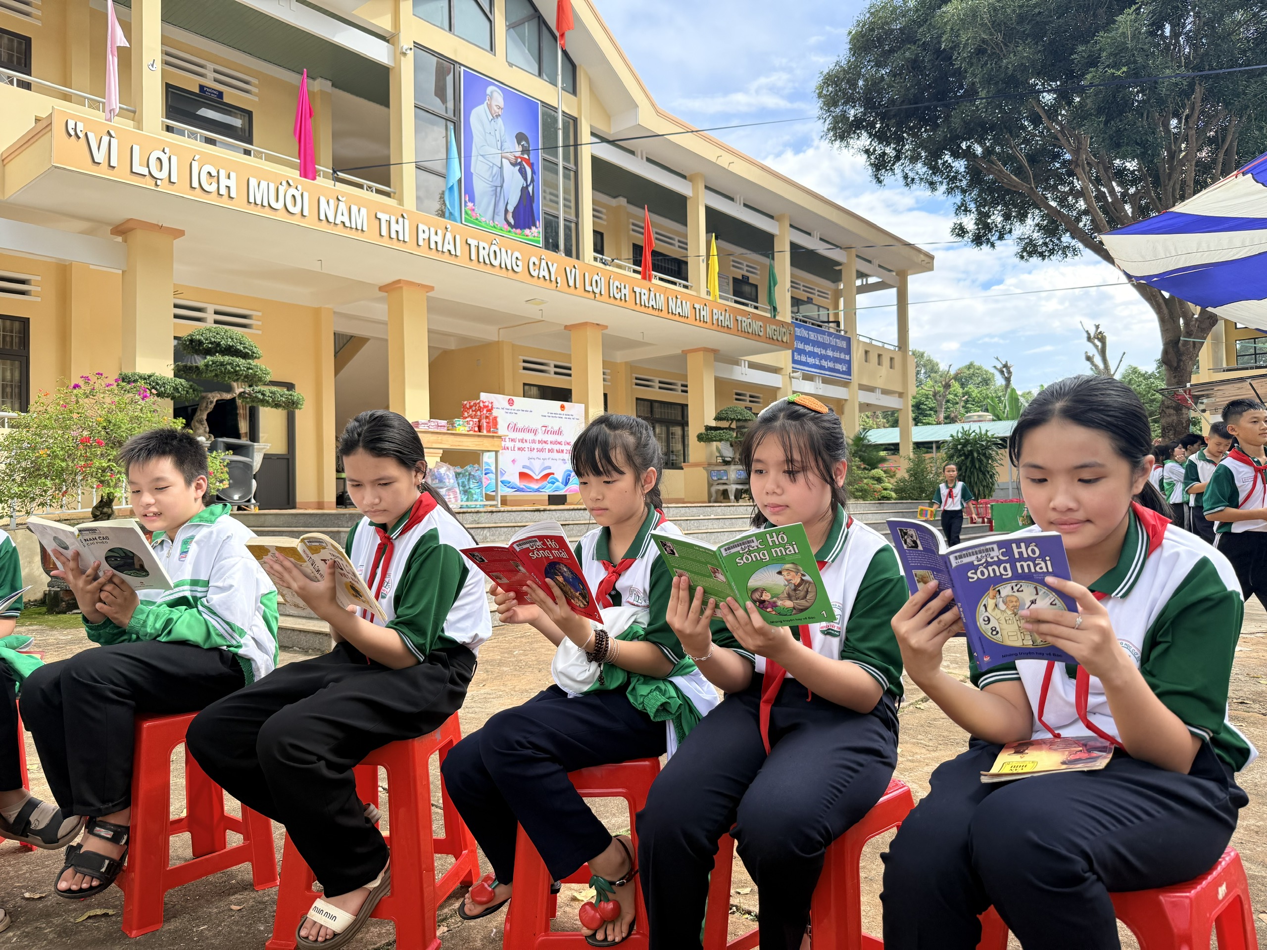 Các em học sinh đọc sách tại xe thư viện lưu động